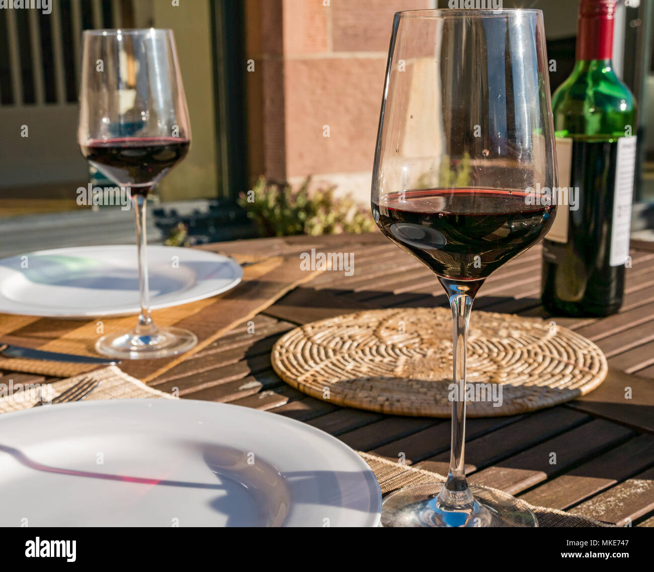 Tisch im Freien mit roten Wein in Gläsern auf sonnigen Abend, Schottland, Großbritannien Stockfoto
