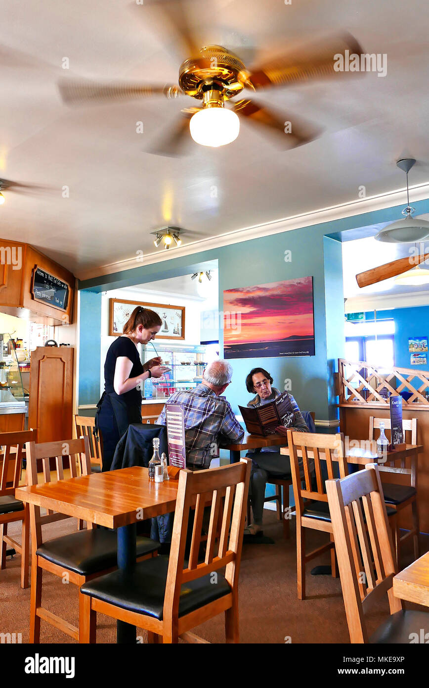 Junge Kellnerin mit einem Essen um von einem Paar mittleren Alters an einem Tisch im Café bei Knott Knott Ende Ende, Wyre, Lancashire, Großbritannien Stockfoto