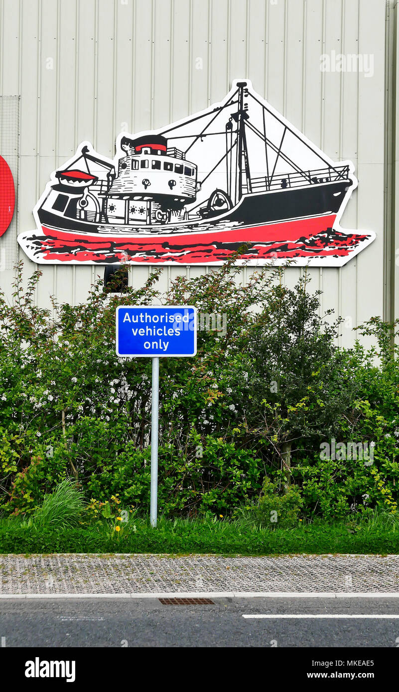 Unglückliche Positionierung eines Straßenverkehr Schild, autorisierte Fahrzeuge nur direkt unter dem Bild eines Fischtrawler auf hoher See Stockfoto