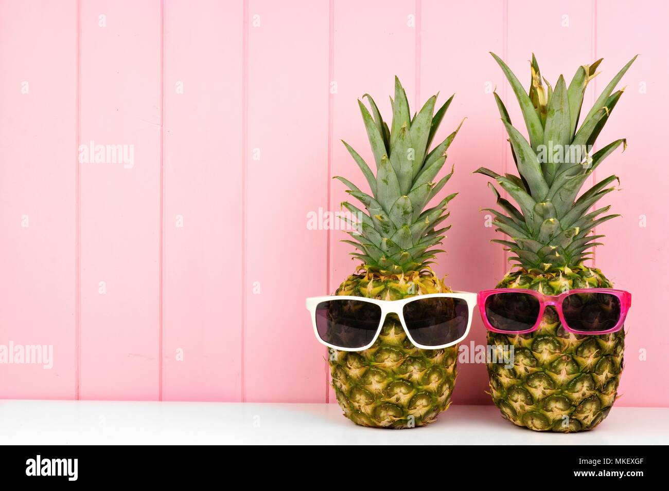 Hipster Ananas mit trendigen Sonnenbrillen gegen Rosa Holz Hintergrund. Minimale Sommer Konzept. Stockfoto