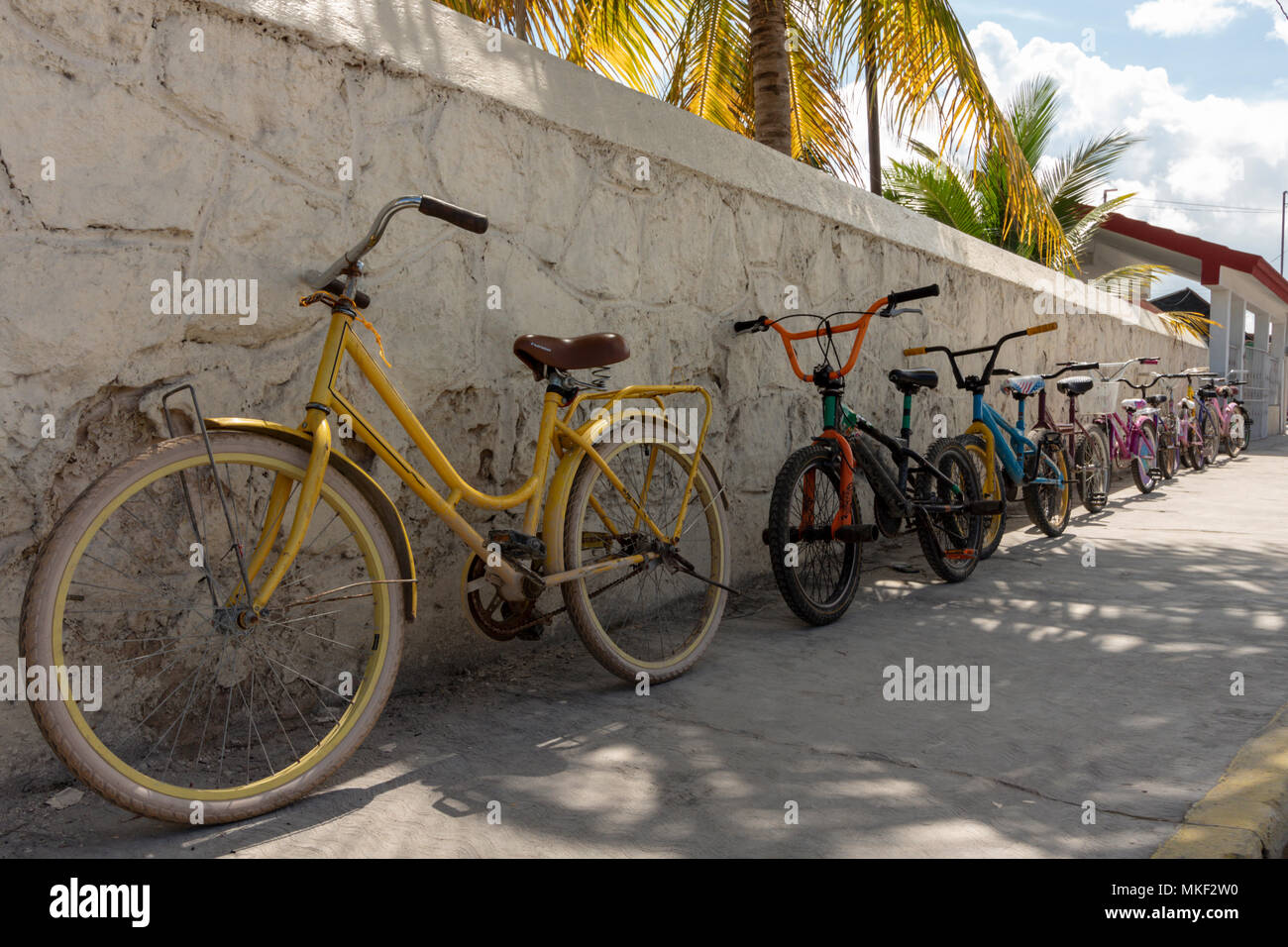 Leere Straßen, Menschen bleiben zu Hause. Caribbean Town in Mexiko fördert die Unabhängigkeit der Kinder. Kinder fahren mit dem Fahrrad zur Schule und parken sie gegen den Wal Stockfoto