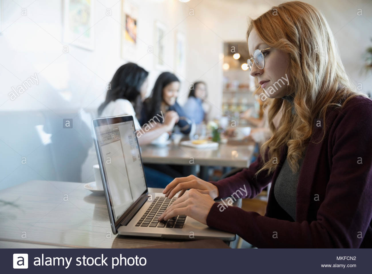 Junge Geschäftsfrau eingeben, mit Laptop im Cafe Stockfoto