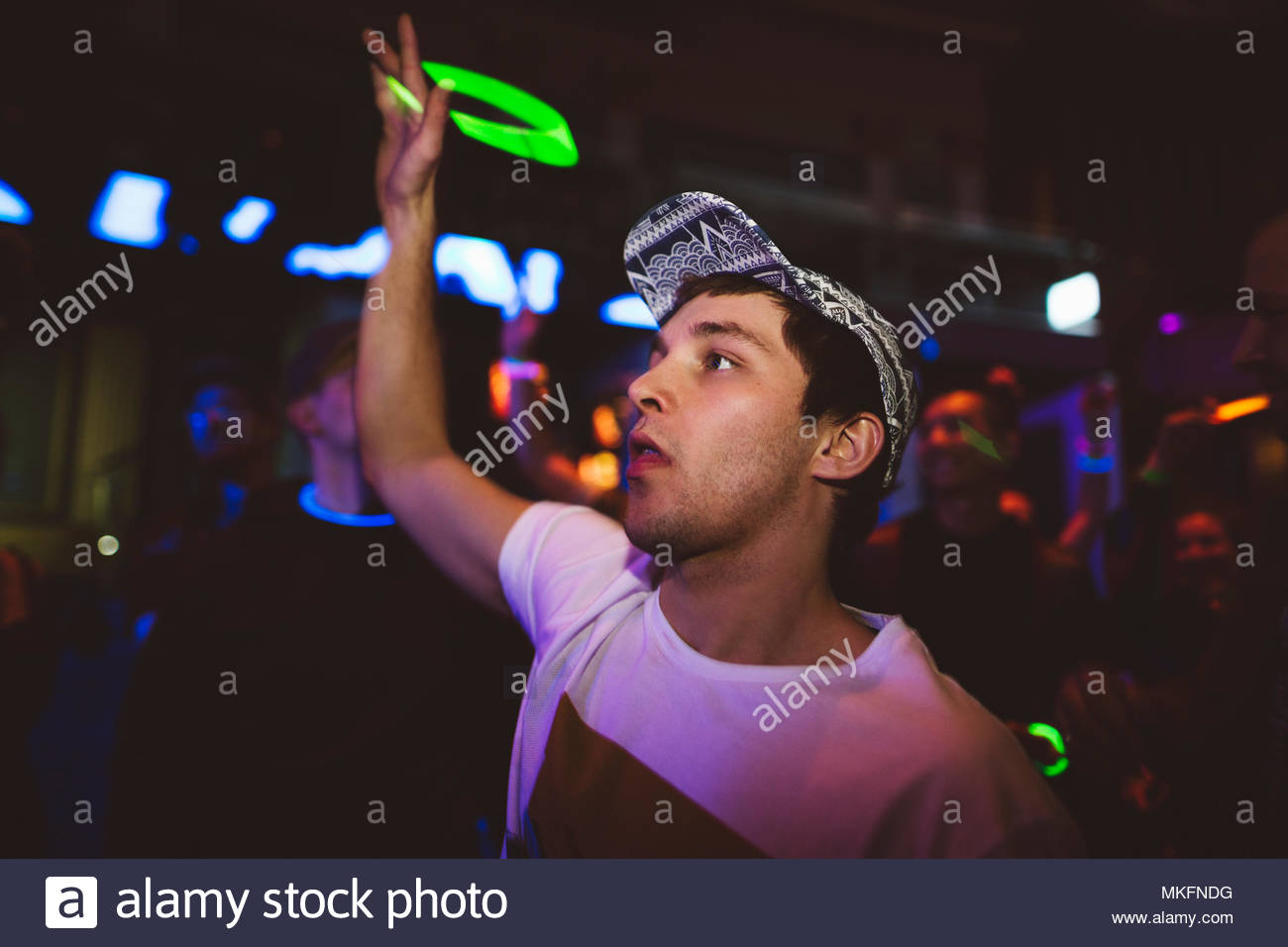 Selbstbewussten jungen männlichen tausendjährigen Tanzen, neon winken LED Halskette in Nachtclub Stockfoto