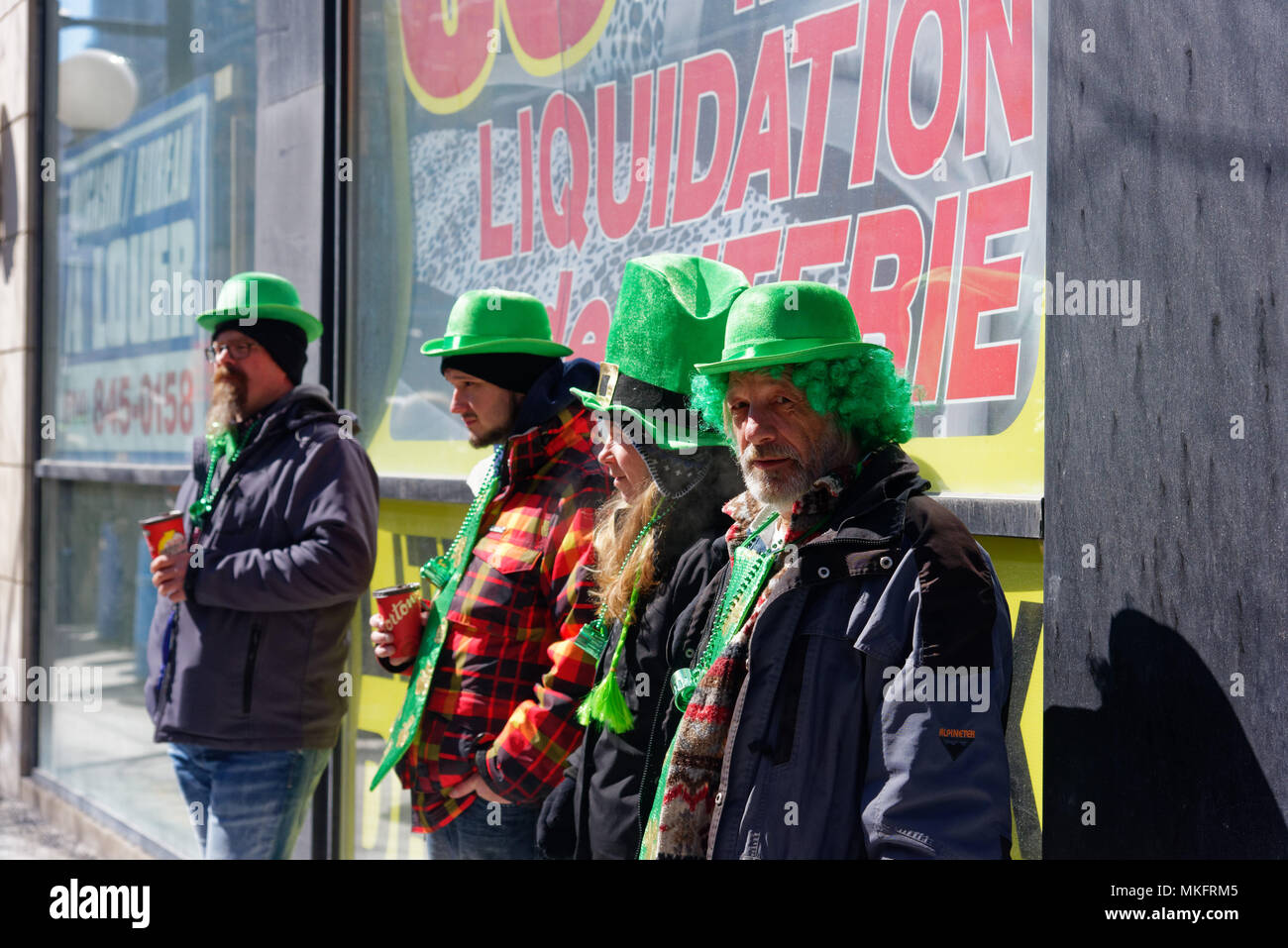 Eine Reihe von vier Männer in grün Hüte und Perücken im Montreal St. Patrick's Day Parade, einem der Fotograf eine dreckig aus. Stockfoto