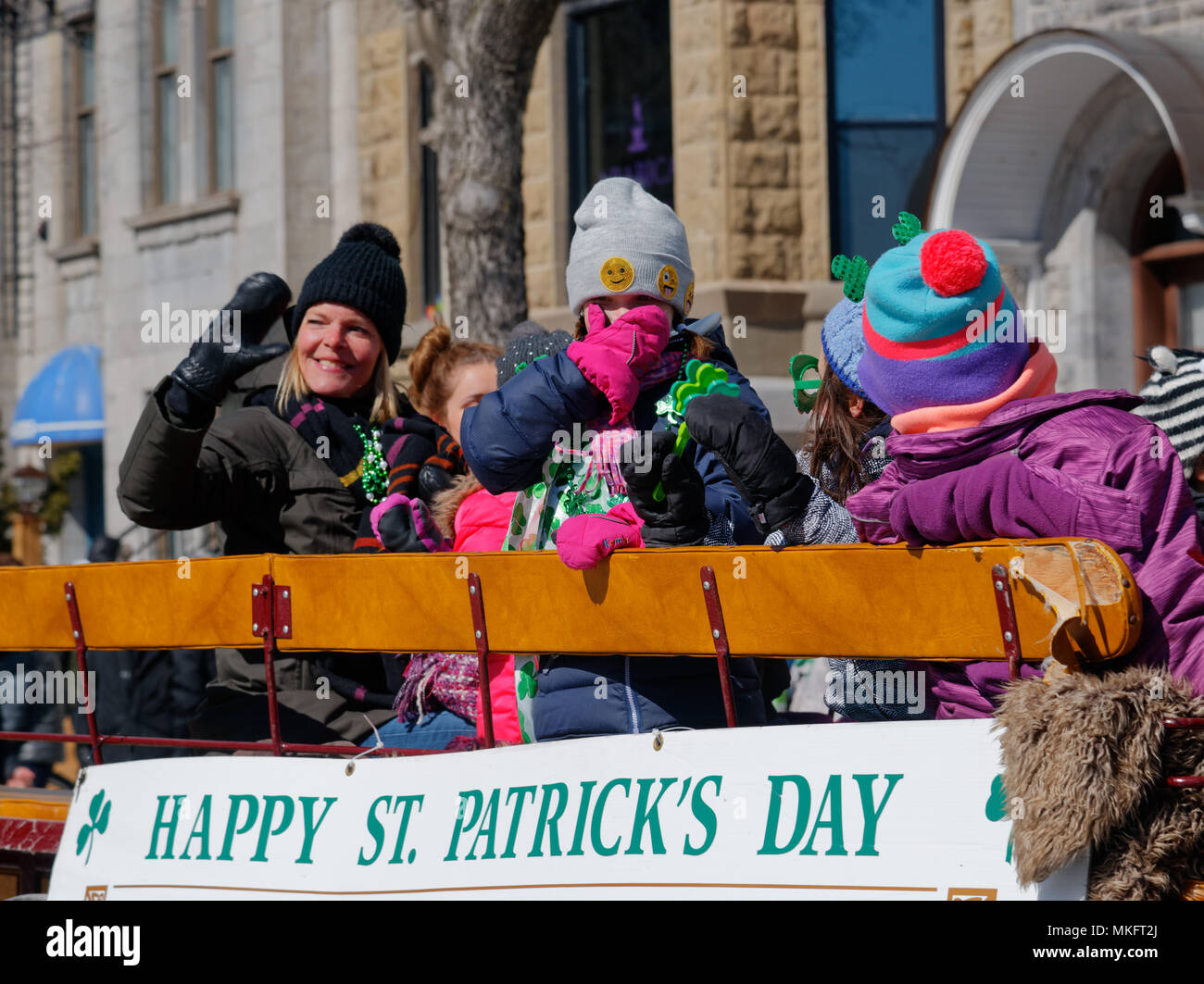 Kinder auf dem St. Patrick's Day Parade float lächelnd und winkend in die Menge Stockfoto