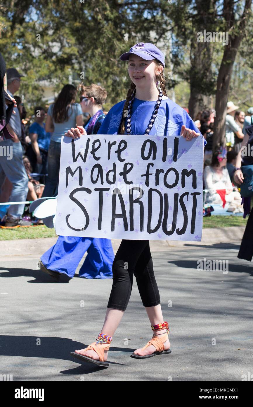 Ein jugendlich Mädchen hält ein Schild mit der Aufschrift 'Wir alle sind aus Sternenstaub" an der May Day Festival in Minneapolis, Minnesota, USA. Stockfoto