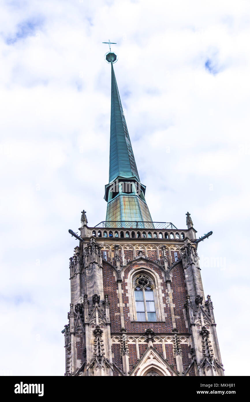 Turm der Kathedrale im gotischen Stil. Ein Kupfer Turmspitze, Windows, Skulpturen, Stein Dekor. Dom St. Johannes der Täufer in Wroclaw, Polen. Stockfoto