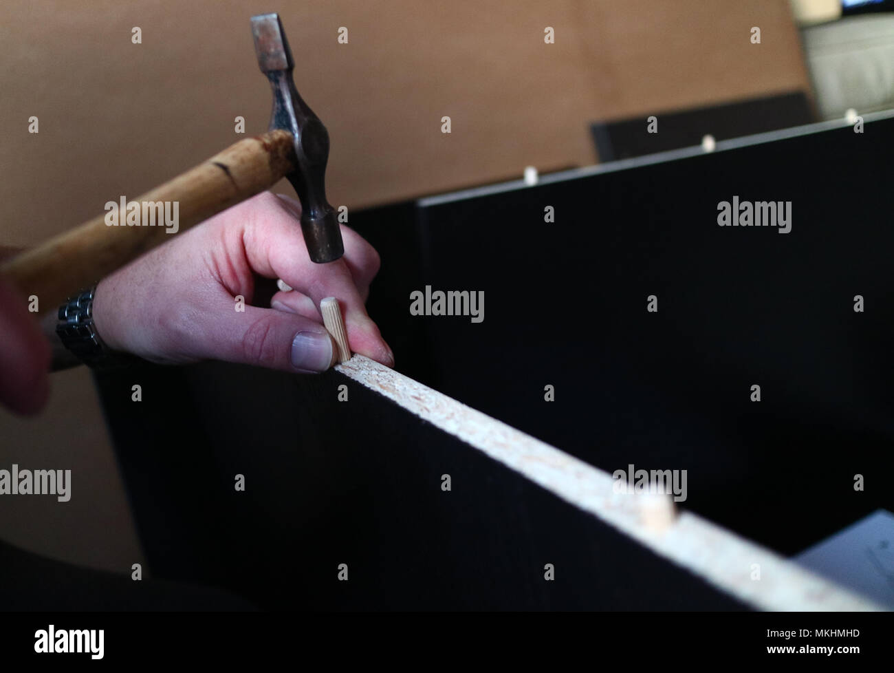 Eine Nahaufnahme der Hände ist ein Mann mit einem Hammer flach zu errichten - pack Möbel Stockfoto