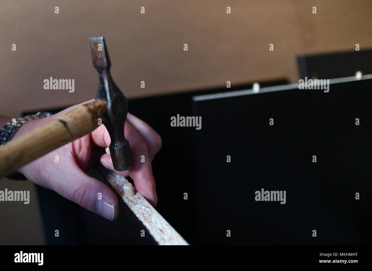 Eine Nahaufnahme der Hände ist ein Mann mit einem Hammer flach zu errichten - pack Möbel Stockfoto