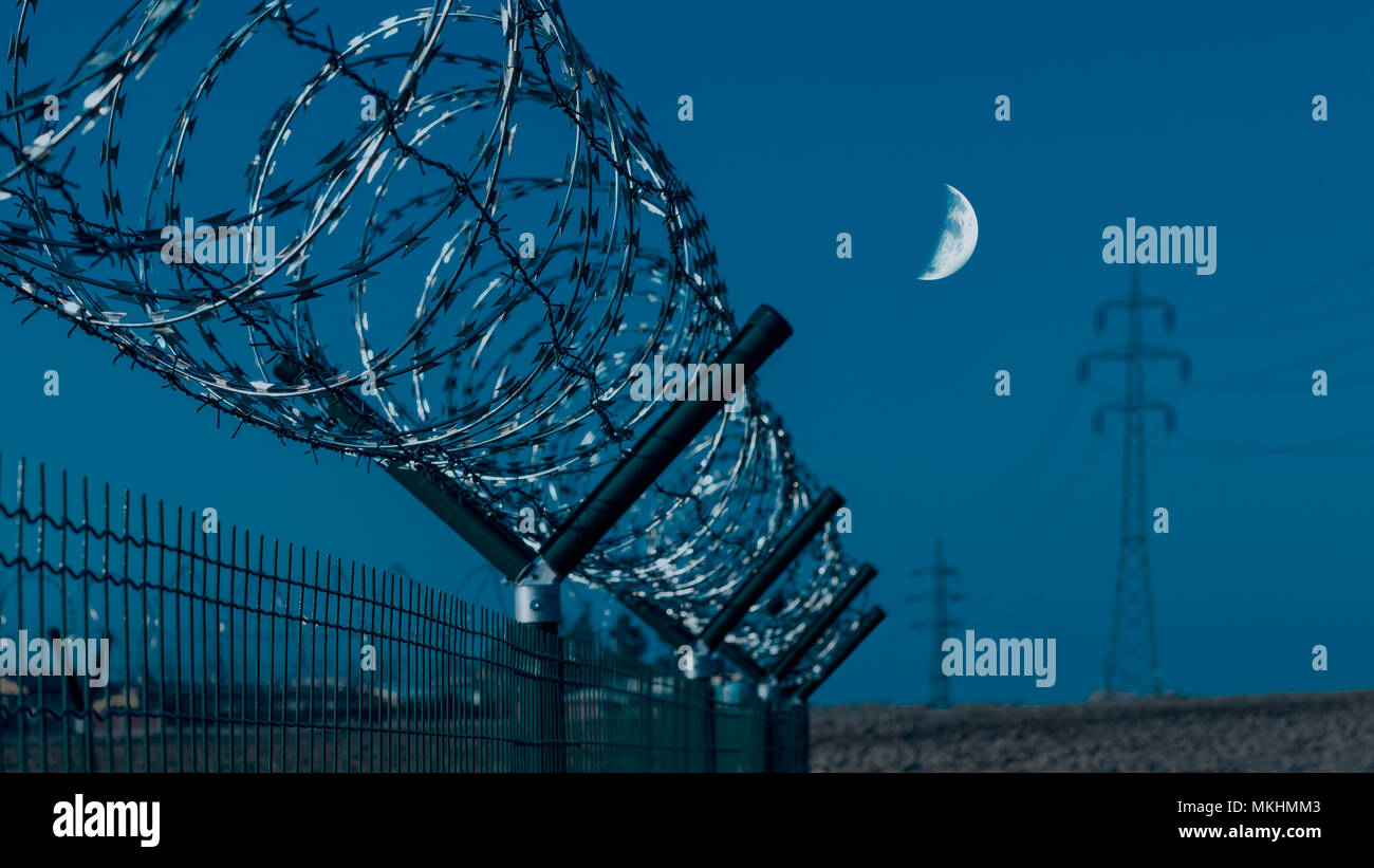 In der Nähe von scharfen Stacheldraht zaun. Düster, blauer Himmel und der Mond im Hintergrund. Abstrakte Industrie- oder militärische Mittel. Barbed tape, Feld, power line. Stockfoto