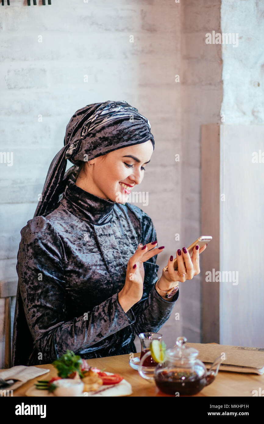 Muslimische Frauen Holding smartphonephone. Denken gute Erinnerungen. serfing social media Stockfoto
