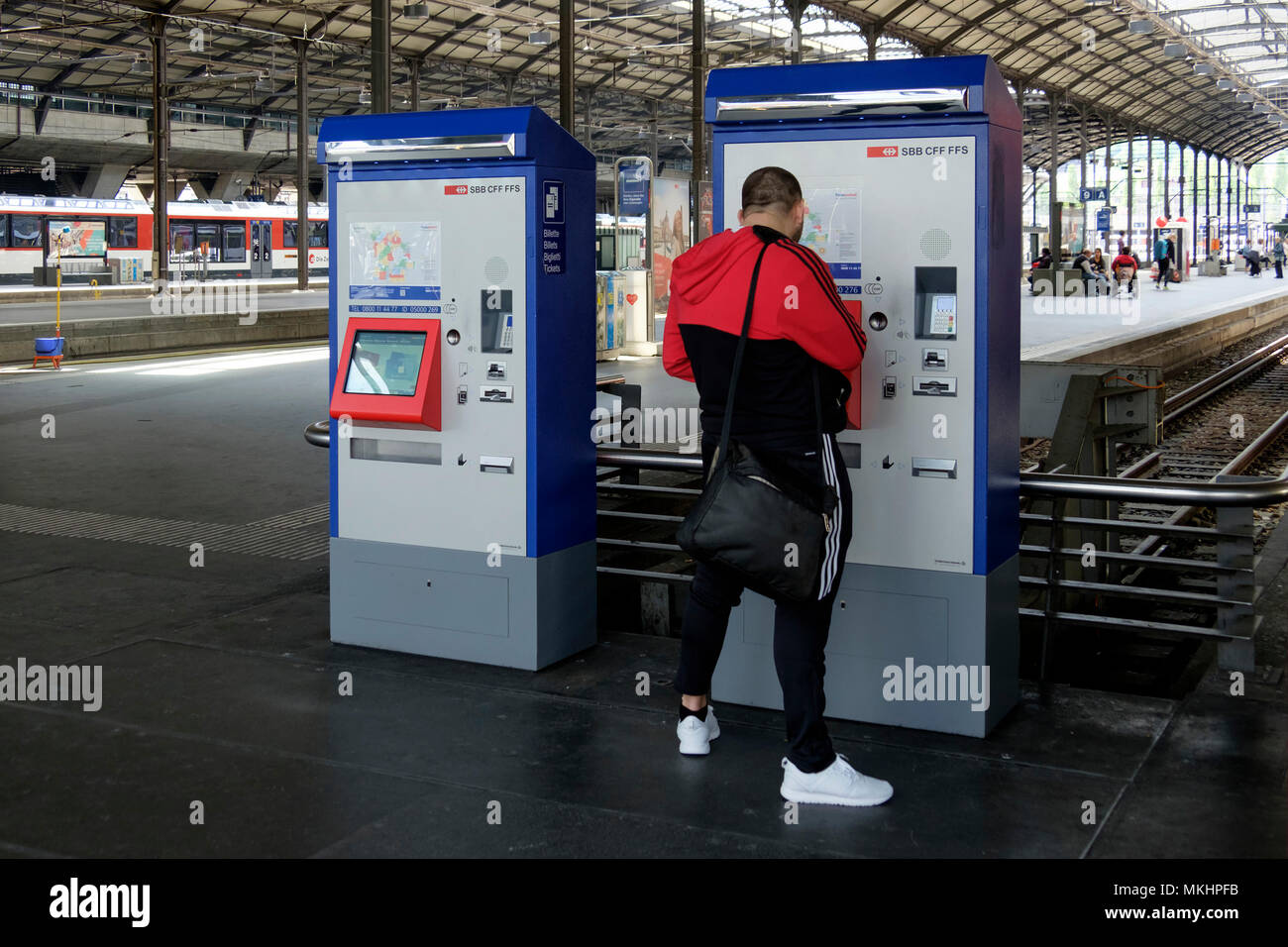 Junger Mann kauft Fahrkarten am Bahnhof in Zürich, Schweiz, Europa Stockfoto