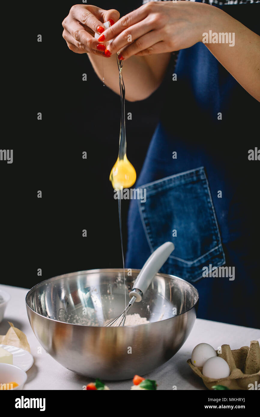 Fallende Eier in Mehl. Hände brechen, reißen ein rohes Ei über Mehl  Stockfotografie - Alamy