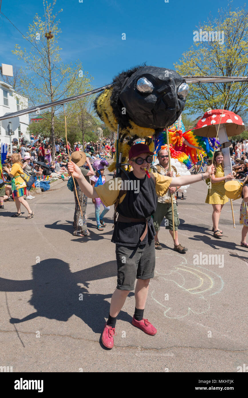 MINNEAPOLIS - 6. Mai 2018: Eine einzelne trägt ein riesen Biene Marionette in Minneapolis jährliche May Day Parade. Stockfoto