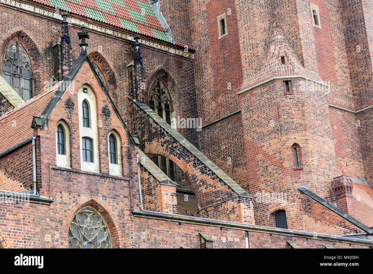 Von außen ein Backstein Kathedrale im gotischen Stil. Türme, Windows, Steindekor, Flying buttress, Dachziegel. St. Maria Magdalena Kirche. Wroclaw, Polen. Stockfoto