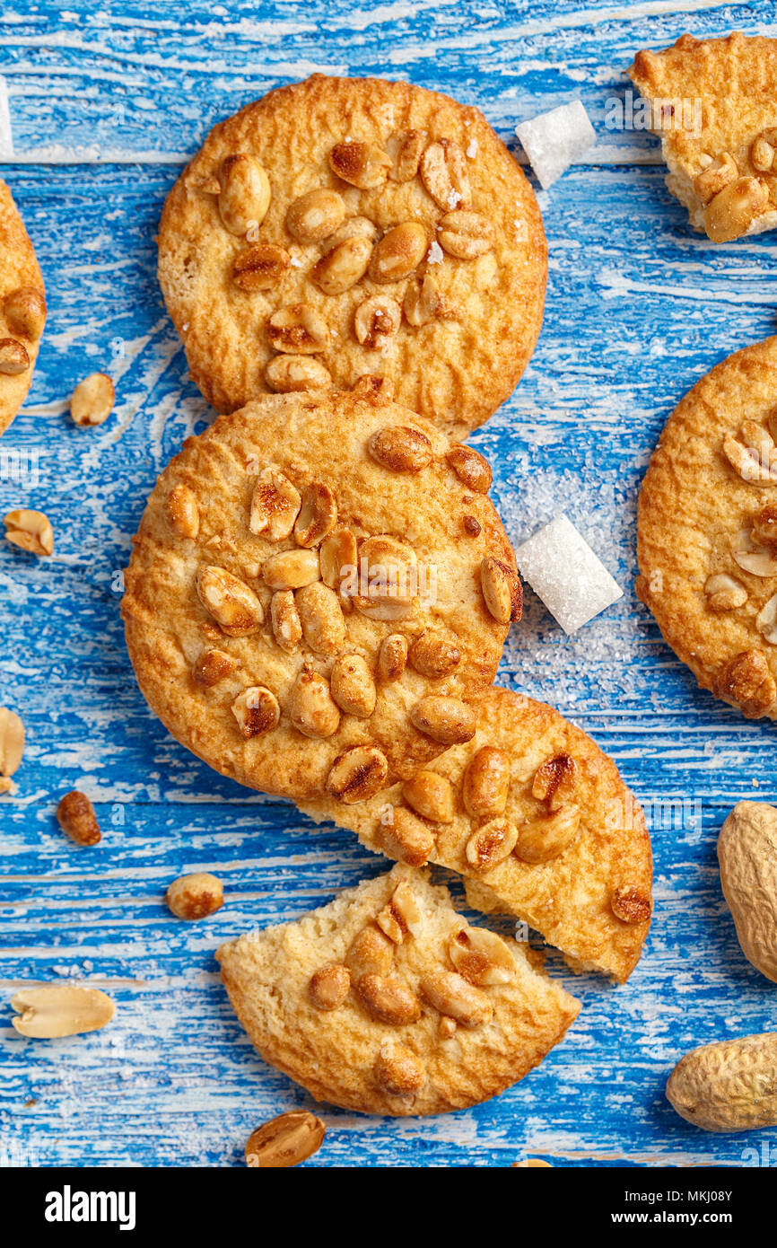 Leckere Cookies mit Erdnüssen auf einem blauen Hintergrund schäbig aus Holz, Kekse gebrochen. Stockfoto