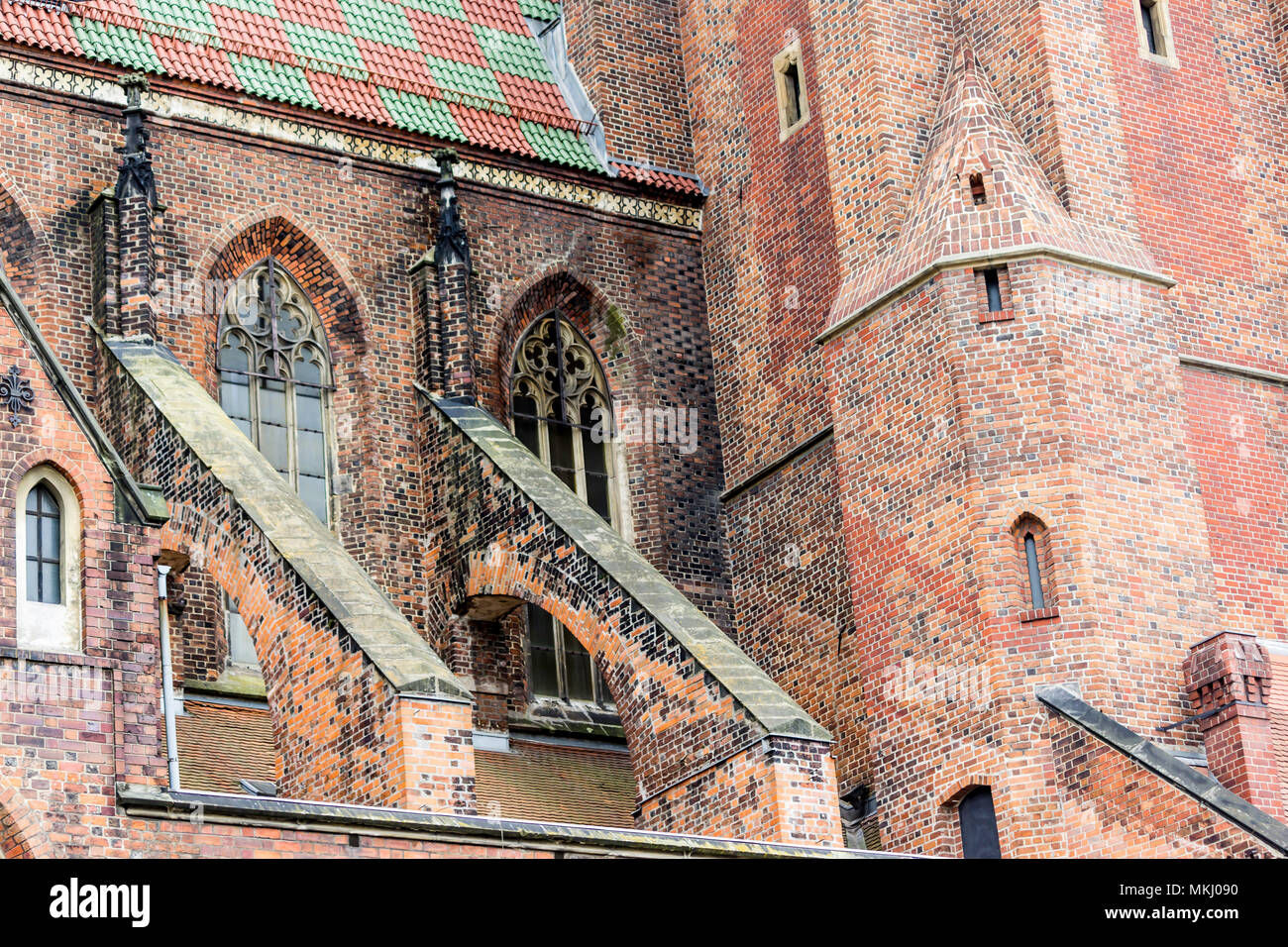 Von außen ein Backstein Kathedrale im gotischen Stil. Türme, Windows, Steindekor, Flying buttress, Dachziegel. St. Maria Magdalena Kirche. Wroclaw, Polen. Stockfoto