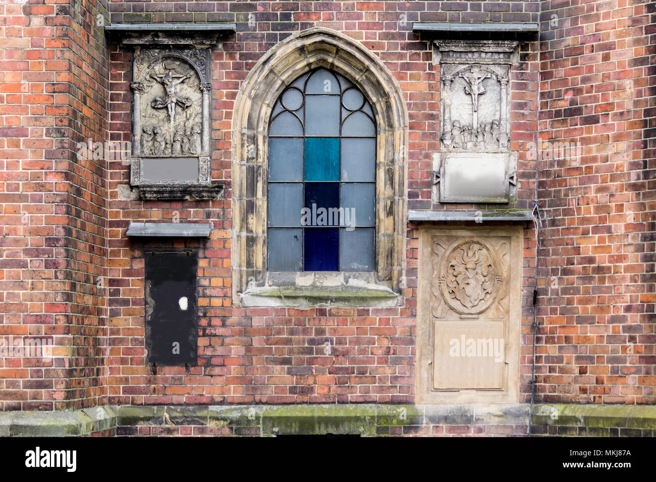 Detail eines Backstein Kathedrale im gotischen Stil. Geschnitzte Reliefs auf der Seite Fassade. Ein lancet Fenster. St. Maria Magdalena Kirche. Wroclaw, Polen. Stockfoto