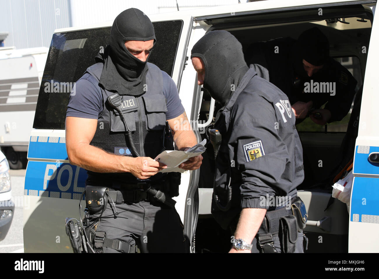 08 Mai 2018, Deutschland, Bremen: Polizisten mit einem Streifenwagen bei einer gross angelegten Razzia stehen. Eine Bande ist der Menschenhandel Hunderte der Moldauer in Deutschland vermutet und sie illegal beschäftigt in Security Services. Foto: Bodo Marks/dpa Stockfoto