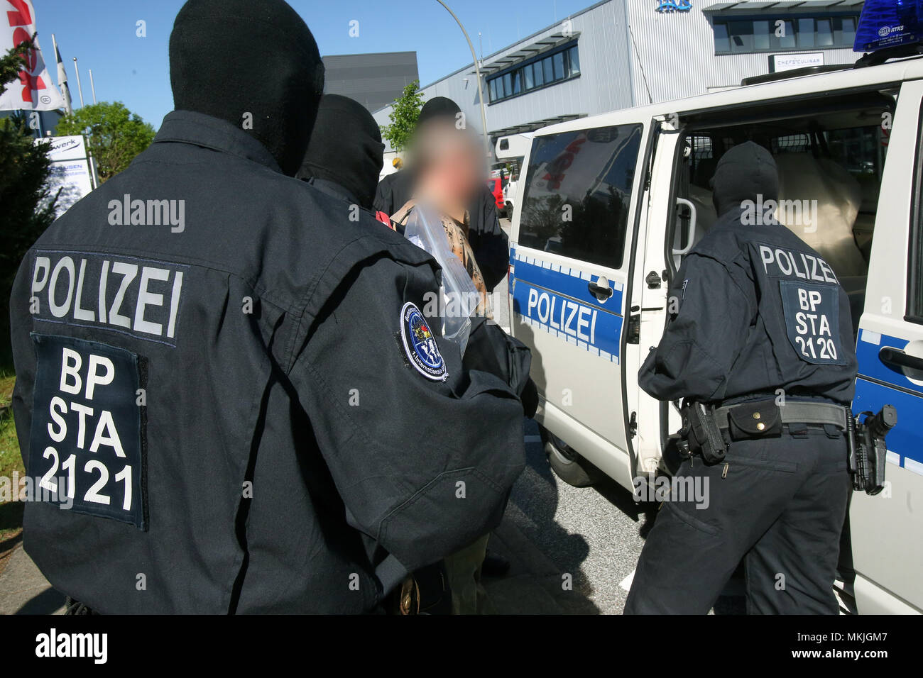 Bremen, Deutschland. 08 Mai 2018, Deutschland, Bremen: Deutsche Polizisten bringen eine verhaftet Verdächtigen zu einem Streifenwagen. Eine Bande ist der Menschenhandel Hunderte der Moldauer in Deutschland vermutet und sie illegal beschäftigt in Security Services. Foto: Bodo Marks/dpa - ACHTUNG: Individuelle(s) ist/sind verpixelt aus rechtlichen Gründen eine Gutschrift: dpa Picture alliance/Alamy leben Nachrichten Stockfoto