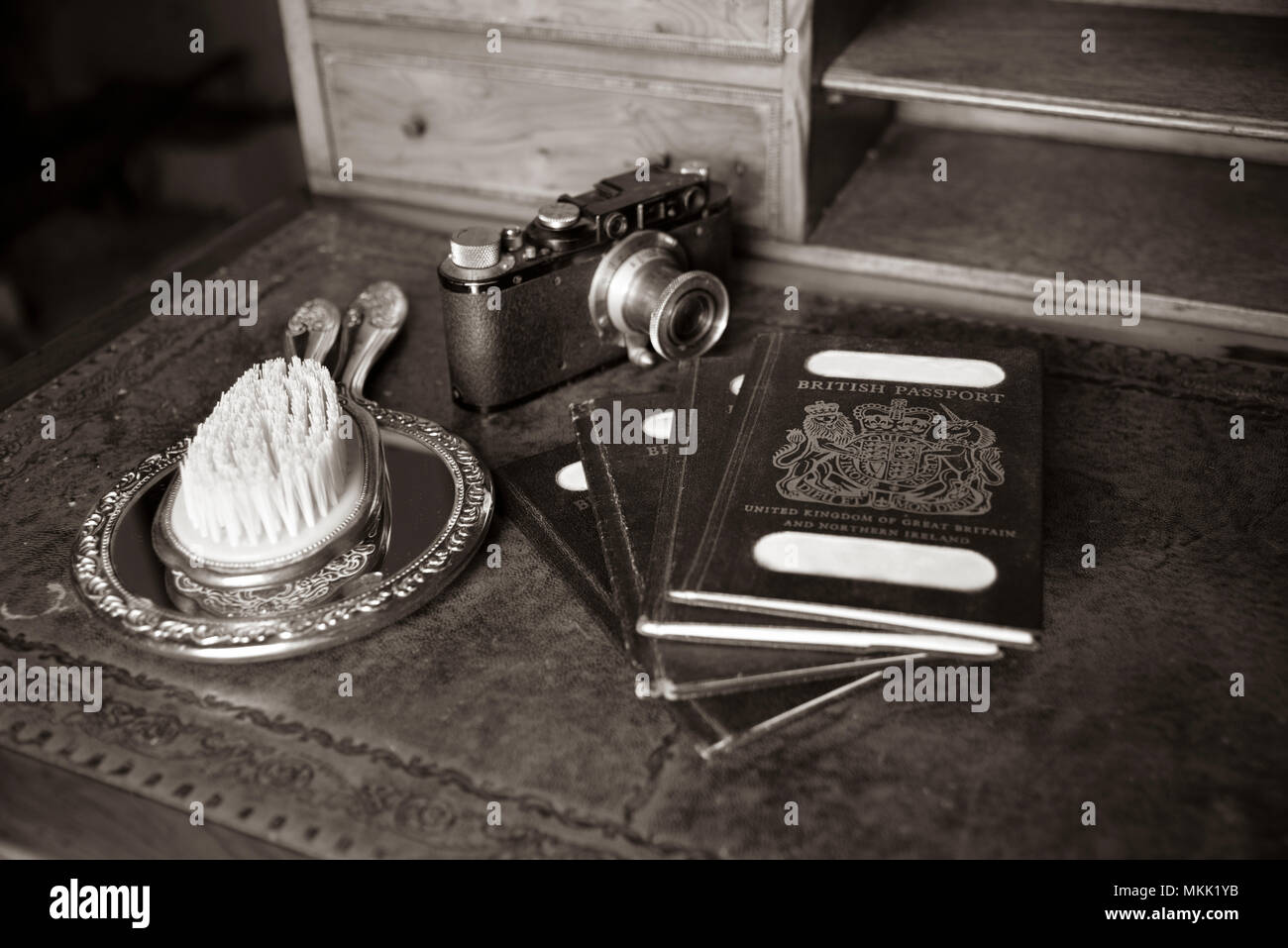 Antike Holz Schreibtisch mit Pässen und Vintage leica II von 1932, vintage Watch, Namen auf Passport ausgeblendet, mit schmalen Tiefenschärfe Stockfoto