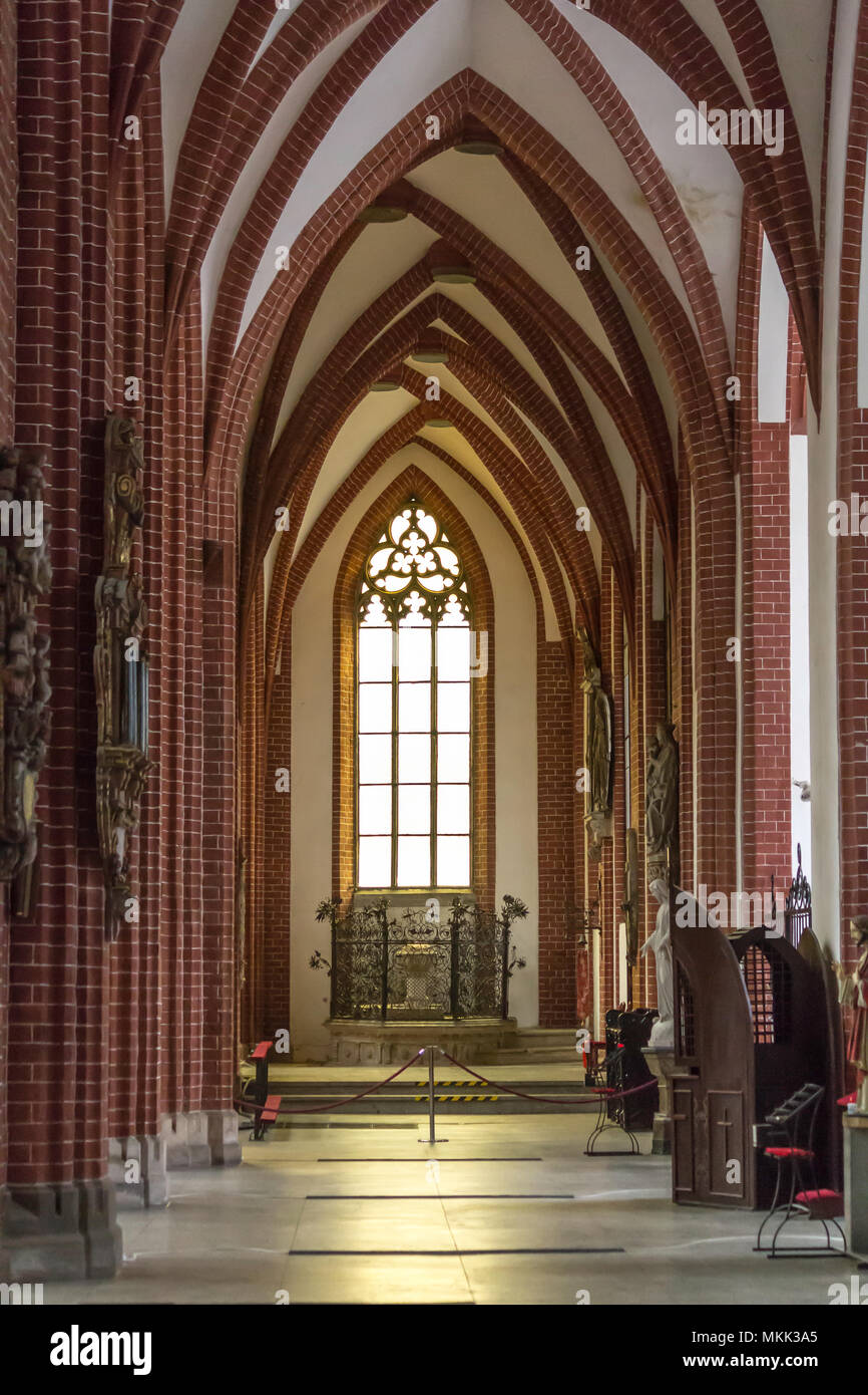 Innenraum eines Ziegelstein Kathedrale im gotischen Stil. eine schmale hohe lanzetten am Ende der seitlichen Kirchenschiff. St. Maria Magdalena Kirche. Wroclaw, Polen. Stockfoto