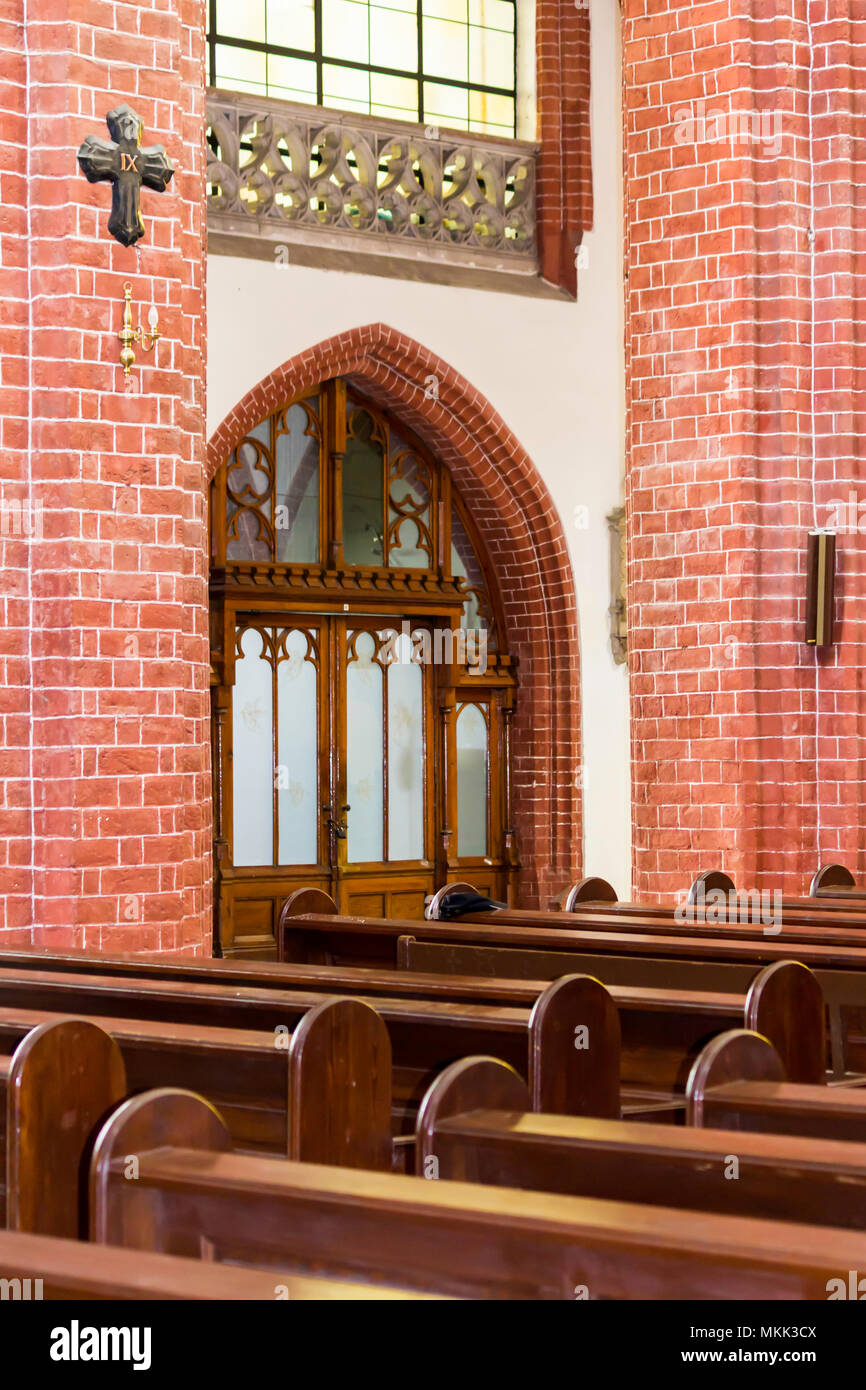Innenraum eines Ziegelstein Kathedrale im gotischen Stil. Holzbänke, Stein und Holz- Einrichtung in das Seitenschiff. St. Maria Magdalena Kirche. Wroclaw, Polen. Stockfoto