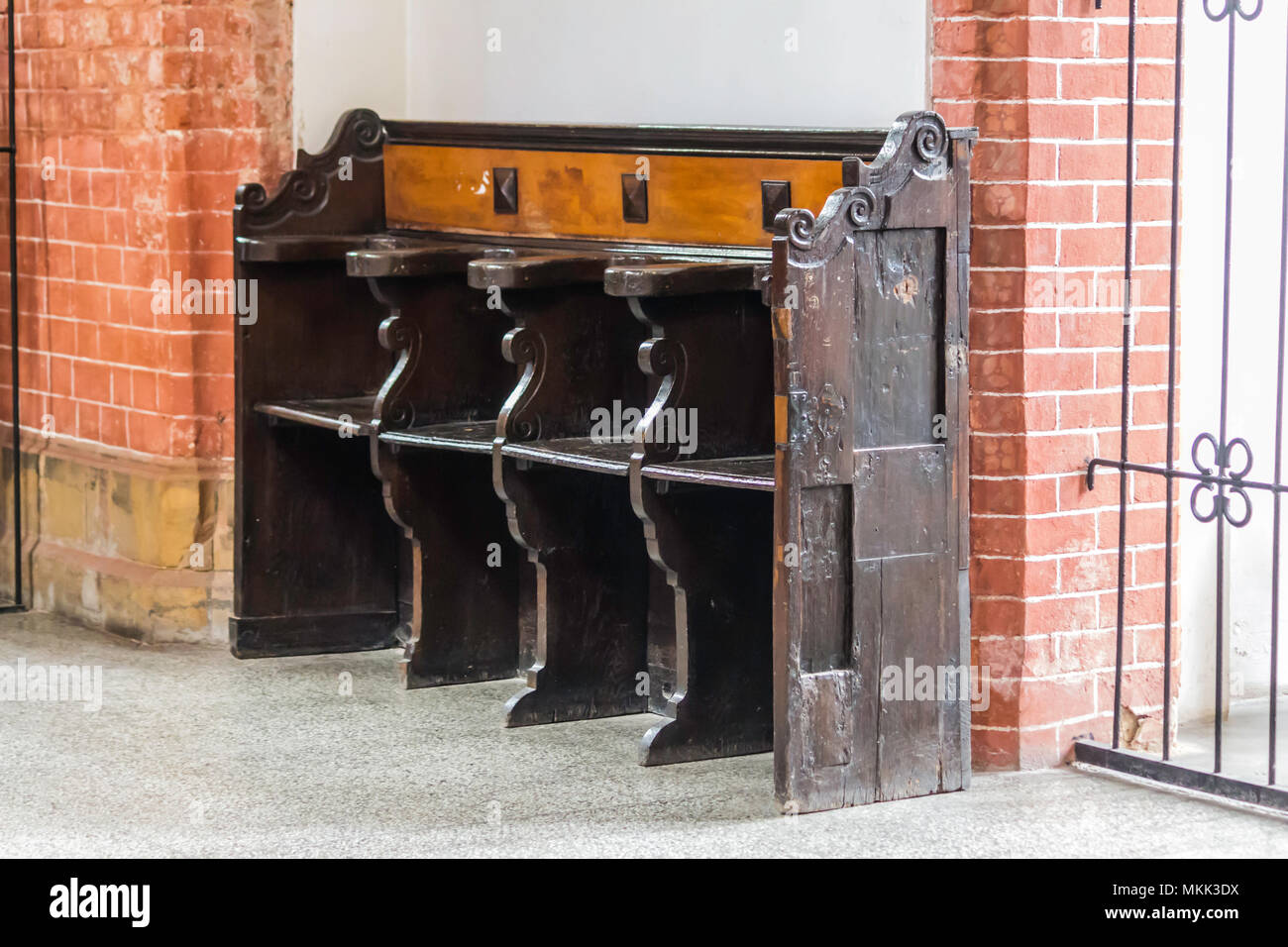 Innenraum eines Ziegelstein Kathedrale im gotischen Stil. Eine alte Holzbank im gotischen Stil im Seitenschiff. St. Maria Magdalena Kirche. Wroclaw, Polen. Stockfoto
