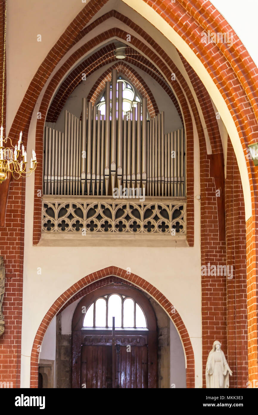 Innenraum eines Ziegelstein Kathedrale im gotischen Stil. Kleine metall Orgel und Eintritt in das Seitenschiff. St. Maria Magdalena Kirche. Wroclaw, Polen. Stockfoto
