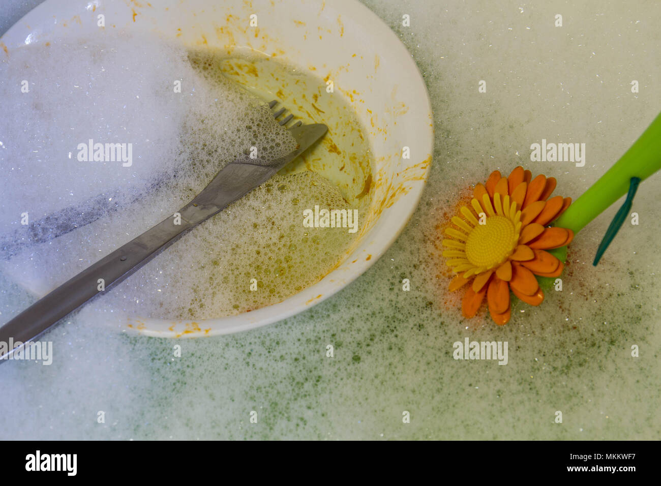 Seifenwasser mit Waschmittel, einem Pinsel und schmutziges Geschirr in der Spüle Bild mit Kopie Raum im Querformat. Stockfoto