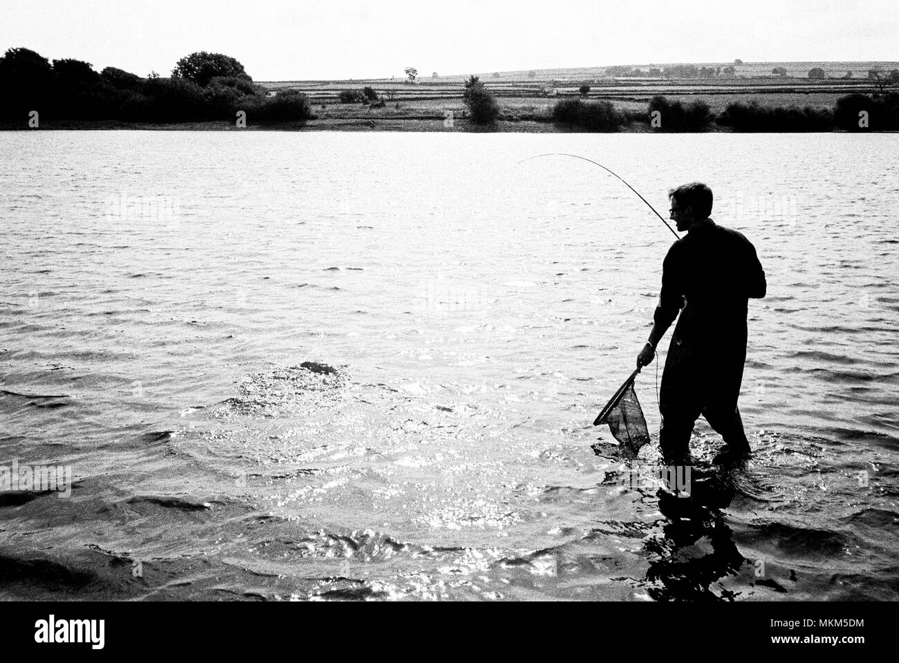 Fischer bei der Scout Deich Reservoir, Penistone Road, South Yorkshire, England, Großbritannien silhouetted Fliegen Stockfoto