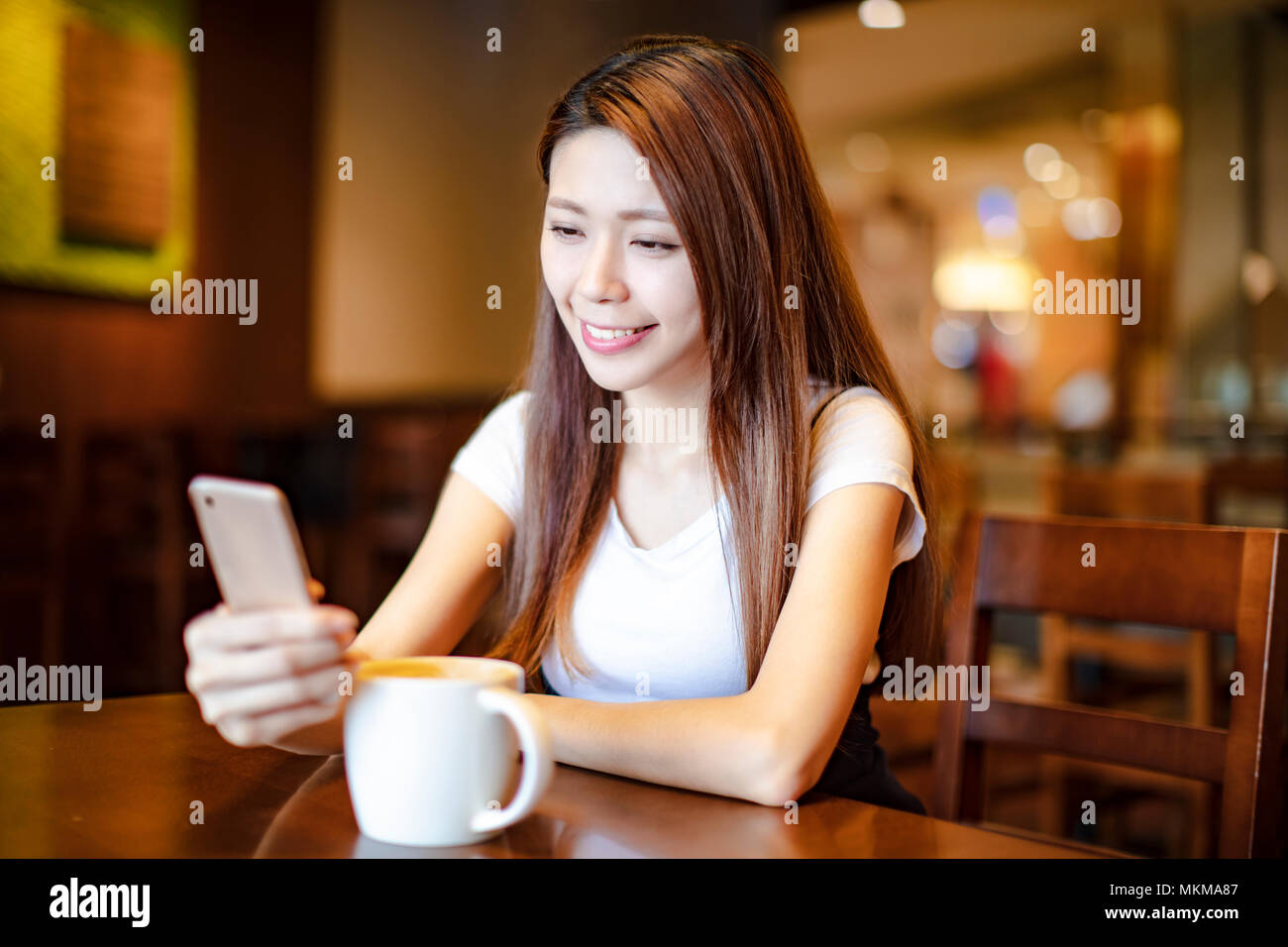 Junge Frau mit smart phone in Coffee Shop Stockfoto