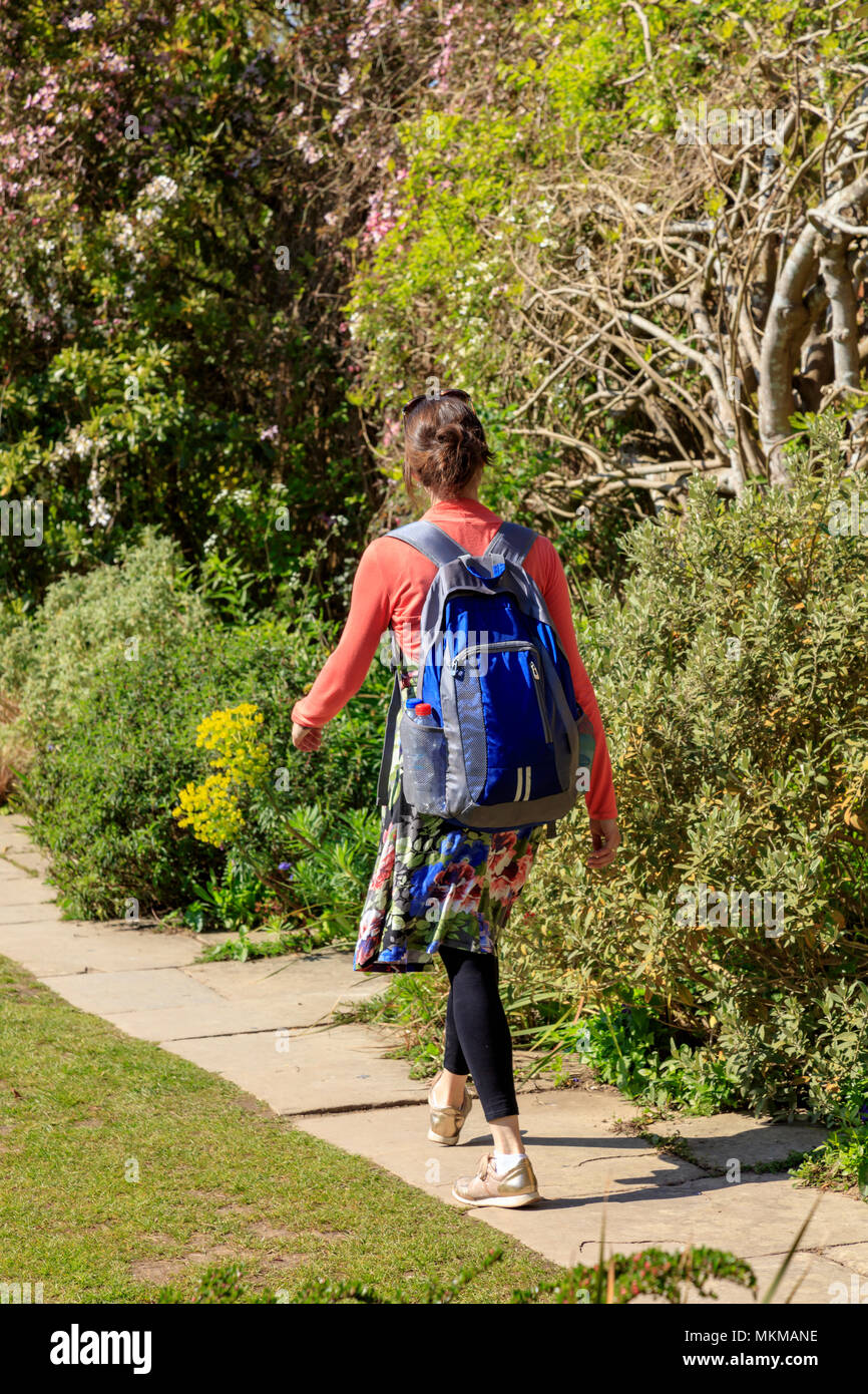 Eine Besucherin im Great Dixter Spaziergänge entlang der langen Grenze trägt einen Rucksack, Ewhurst, East Sussex, Großbritannien Stockfoto