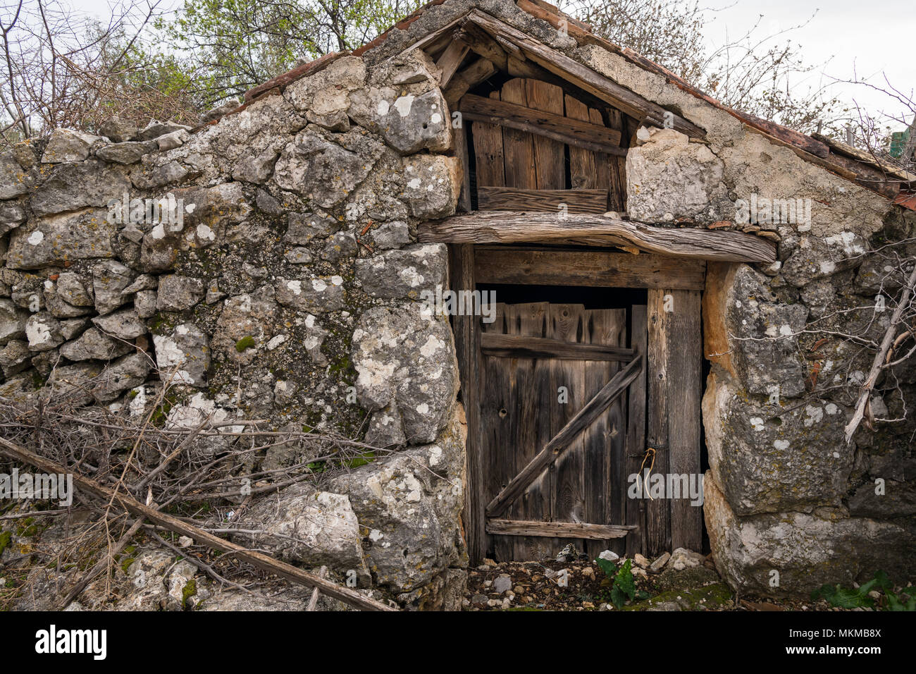Sehr alte verwitterte braune Tür aus Holz, Stein (Insel Cres, Kroatien) Stockfoto