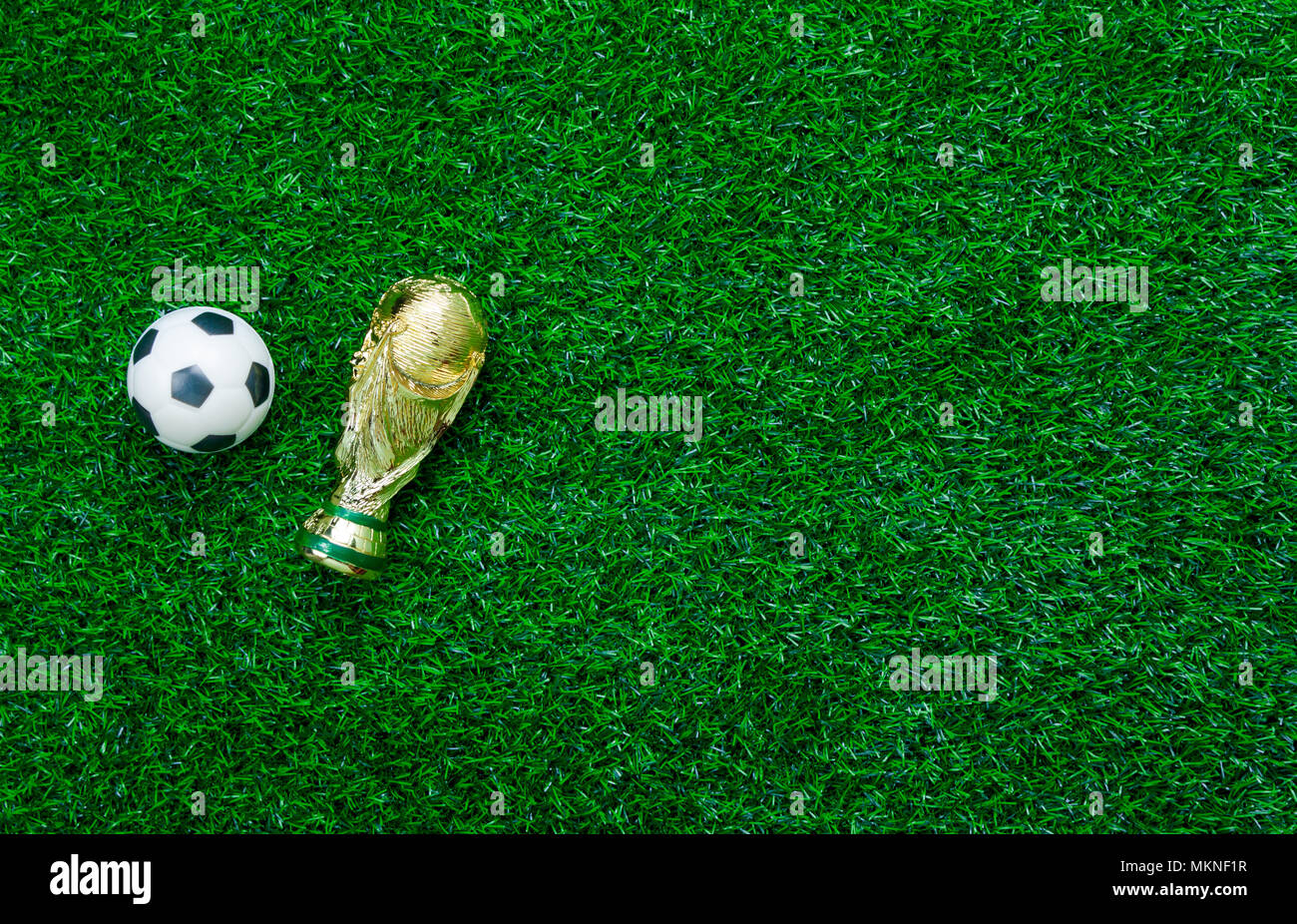 Tabelle Blick von oben auf die Fußball-WM oder Fußball-WM Saison Hintergrund. Flach Objekte Trophy & Kugel auf der künstlichen grünen Gras wallpaper. Freier Speicherplatz fo Stockfoto