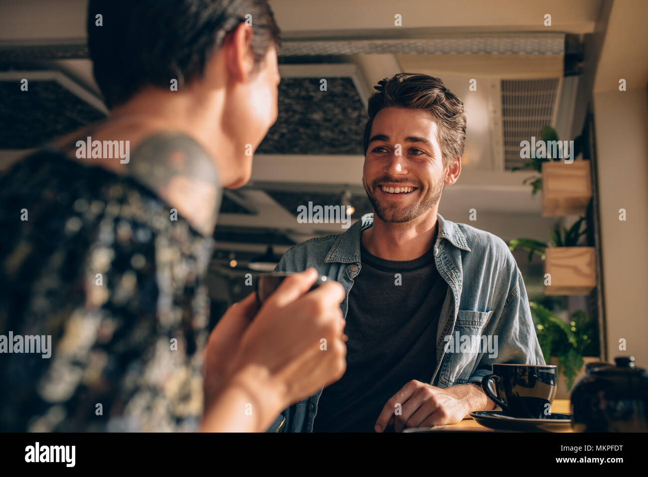 Schöner Mann im Gespräch mit seiner Freundin in einem Café. Paar Begegnung in einem Coffee Shop. Stockfoto