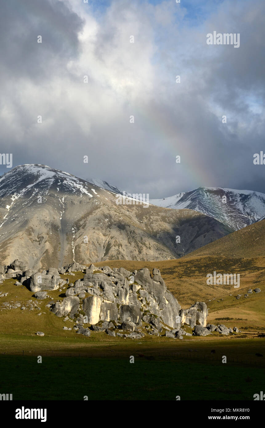 Ein schwaches Rainbow hängt über die kalksteinfelsen der Castle Hill, Südinsel, Neuseeland Stockfoto