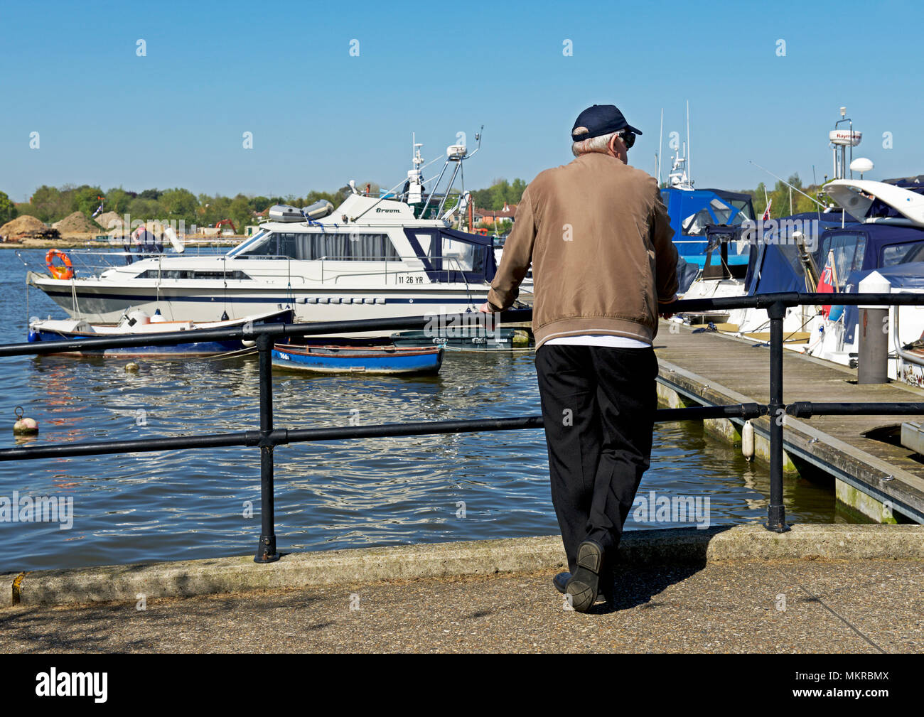 Mann an Boote anstarren, Oulton Broad, in der Nähe von Lowestoft, Norfolk Broads, Norfolk, England Großbritannien Stockfoto