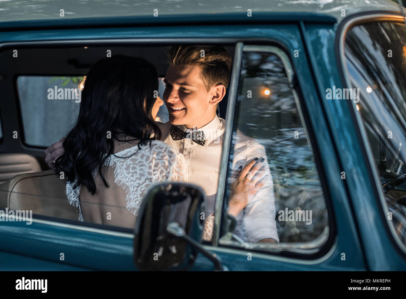 Fröhliches glückliches junges Paar sitzen in der retro-Kleinbus. Stockfoto