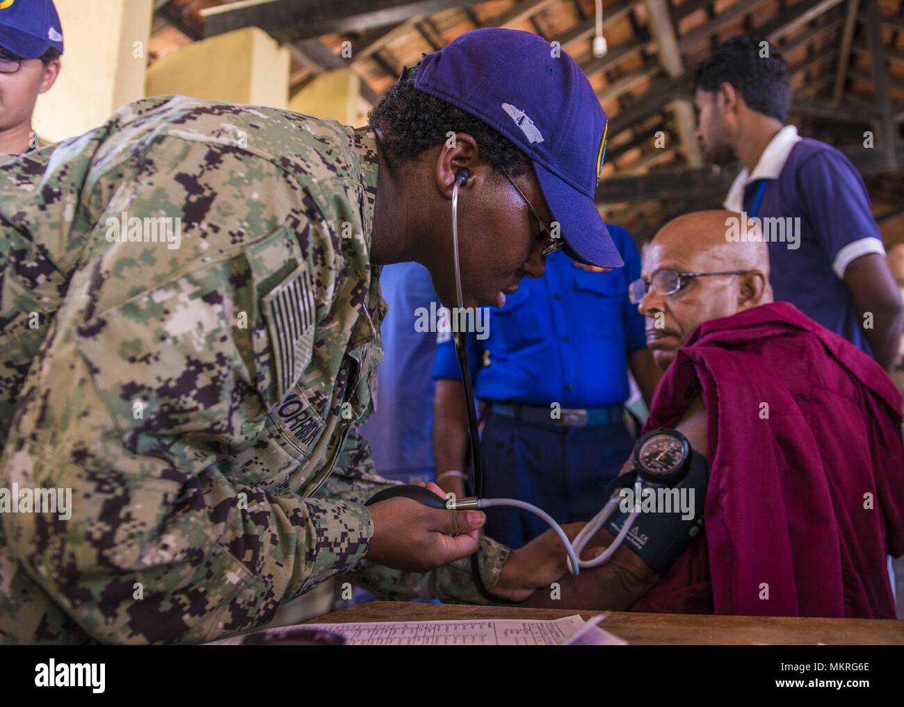 180503-N-FV 739-059 TRINCOMALEE, Sri Lanka (Mai 3, 2018) - Hospital Corpsman 3. Klasse Whitney Morrison, heimisch in Mobile, Alabama, zugeordnet zu den Military Sealift Command Hospital Ship USNS Mercy (T-AH 19), überprüft die Vitalparameter eines nativen Sri Lankan an Sampur Mahavithiyalayam Volksschule während einer Gemeinschaft Gesundheit Engagement, 3. Mai 2018. Barmherzigkeit ist zur Unterstützung der pazifischen Partnerschaft 2018 (PP18) bereitgestellt werden. PP18's Mission ist es, gemeinsam mit Gastgeber und Partner Nationen zu arbeiten regionaler Interoperabilität und Disaster Response Funktionen, mehr Stabilität und Sicherheit in der Region zu stärken, und Stockfoto