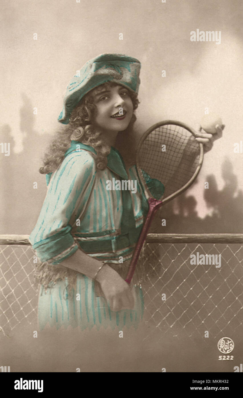 Frau im blauen Kleid mit Tennisschläger und Ball Stockfoto