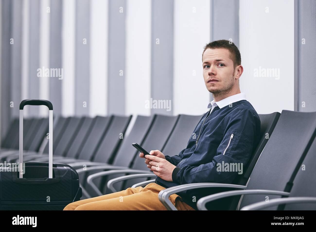 Mann mit dem Flugzeug reisen. Junge Passagier im Terminal warten. Stockfoto
