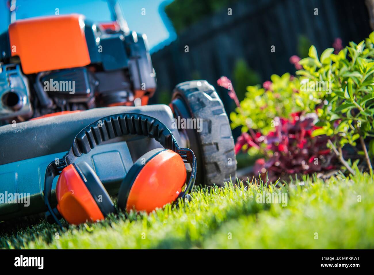 Gehörschutz bei der Arbeit mit Elektrowerkzeugen im Garten. Gehörschutz und der Rasenmäher closeup Foto. Stockfoto