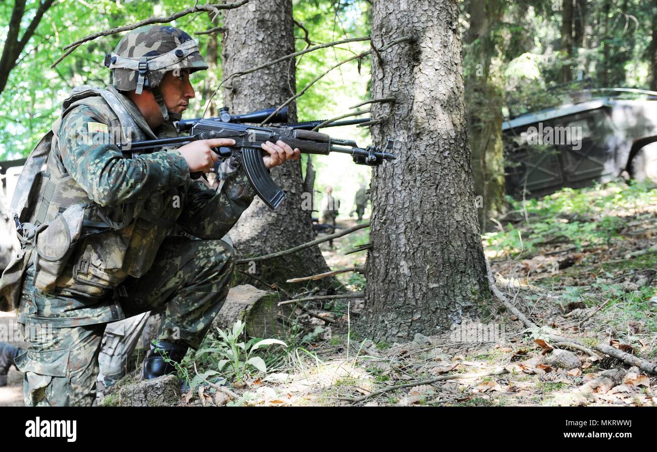 Ein albanischer Soldat mit Alpha Company, Commando Bataillon, in eine kniende Kampfstellung in Hohenfels, Hohenfels, Deutschland bekommt, während der kombinierten Lösung X, Mai 06, 2018, 6. Mai 2018. Kombinierte Lösung X umfasst rund 3 700 Teilnehmer aus 13 Nationen an der 7th Army Training Befehl Grafenwöhr und Hohenfels Training Area, 9. April, 12. Mai 2018. Kombinierte Lösung ist ein US-Army Europe - Regie multinationale Übung Serie entwickelt, um die Armee des zugewiesenen regional zu kampfbrigaden nach Europa ein Combat Training Center Rotation mit Gelenk, multinationalen Envir geben Stockfoto