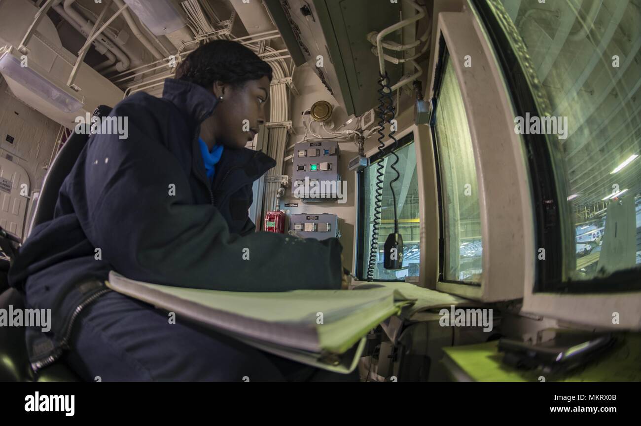 180507-N-ZK 016-0010 5. US-Flotte BEREICH VON OPERATIONEN (7. Mai 2018) der Luftfahrt Bootsmann Mate (Handling) 3. Klasse Charmeise Raeford, von Washington, D.C. steht während der Flugbewegungen im Hangar Bay an Bord der Wasp-Klasse amphibisches Schiff USS Iwo Jima (LHD7), 7. Mai 2018, 7. Mai 2018. Iwo Jima homeported in Mayport, Florida ist für die Bereitstellung in die USA 5 Flotte Bereich für Maßnahmen zur Erhöhung der Sicherheit des Seeverkehrs Operationen Verbündeten und Partnern zu beruhigen, und der Freiheit der Schiffahrt und des freien Handels in der Region erhalten. (U.S. Marine Foto durch Massenmedien. Stockfoto