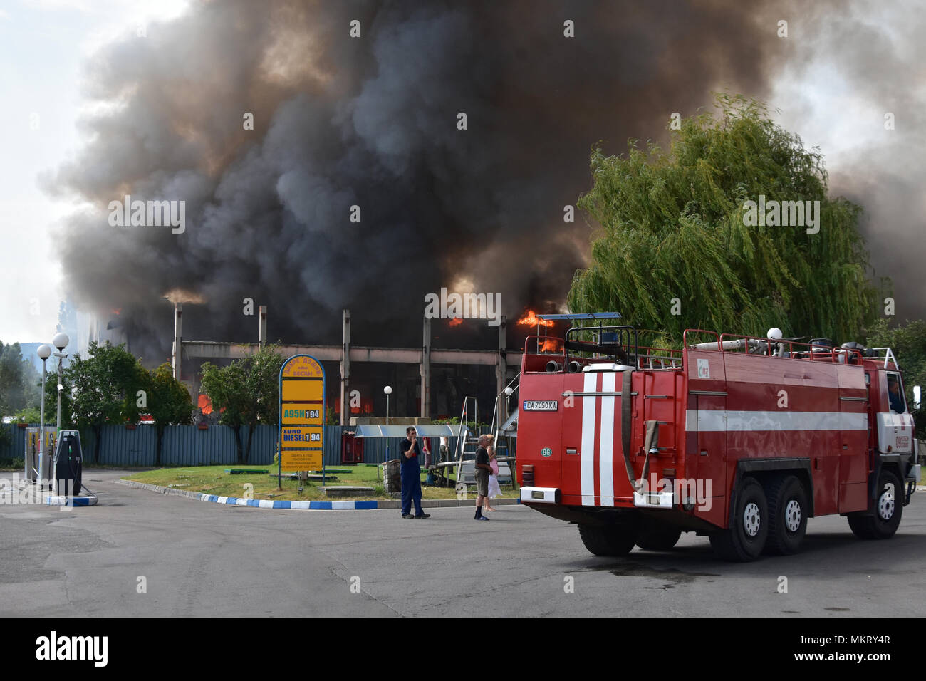 Sofia, Bulgarien - 15. Juli 2017: Großbrand in Kleidungsstück Lager direkt neben einer Tankstelle in Kazichene - Sofia Stadtrand. Feuerwehrmänner einfach ankommen Stockfoto