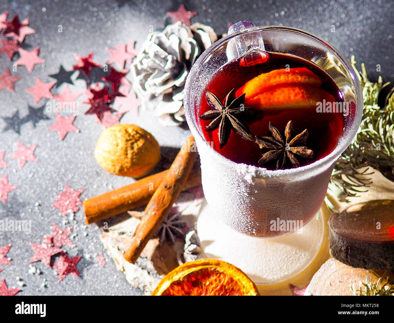 Weihnachten Glühwein mit Gewürzen in glasswith Plaid und Schnee auf einen Weihnachtsbaum auf dunklem Hintergrund, das Glas Tasse heißer Winter trinken Stockfoto