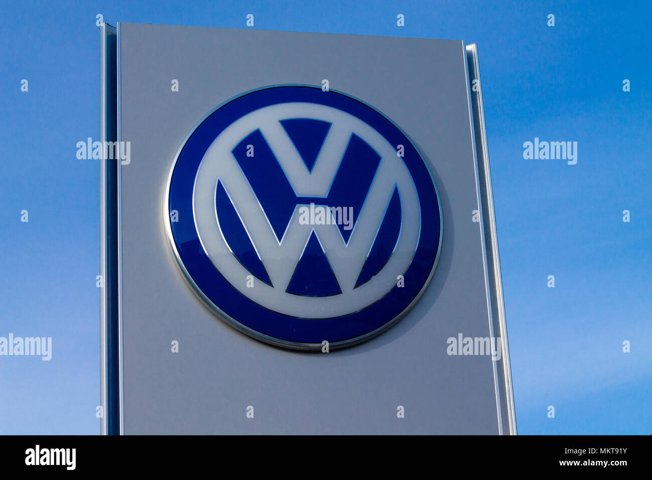 Volkswagen Logo ein deutsches Auto Herstellung Firmenlogo oder Abzeichen heraus, gegen einen strahlend blauen Himmel. Stockfoto