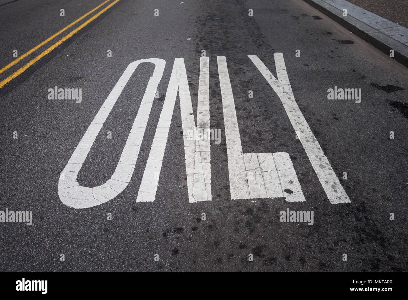 Das Wort "nur" in Großbuchstaben auf einer Straße lackiert Stockfoto