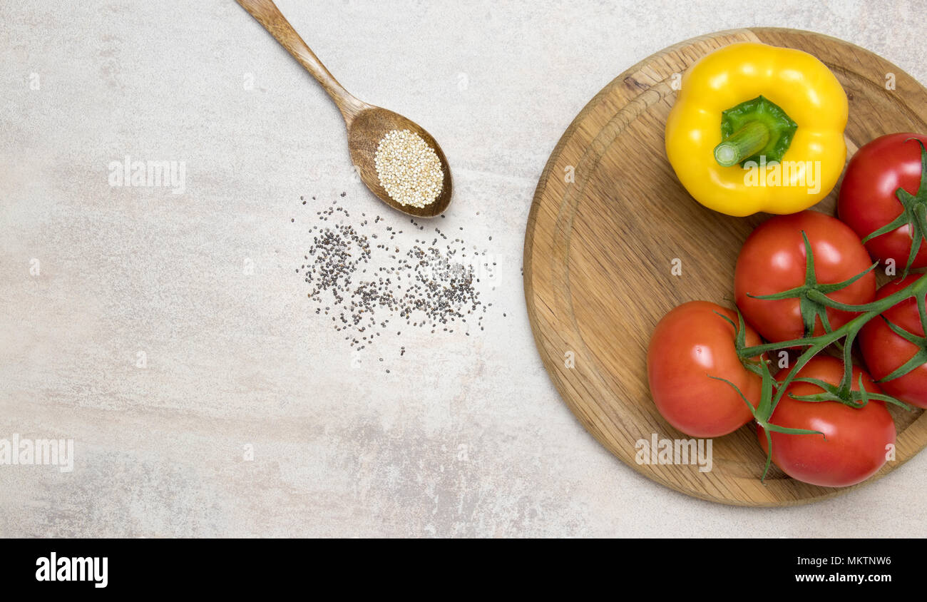 Tomaten und gelbe Paprika auf Holz rund um den Löffel mit Chia Samen. Stockfoto